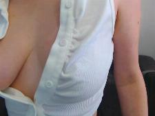 Una piccola webcam girl con i capelli castani durante il camsex