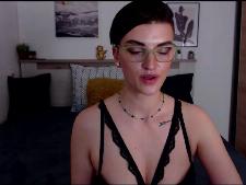 Una camgirl media con i capelli castani durante il sesso in webcam